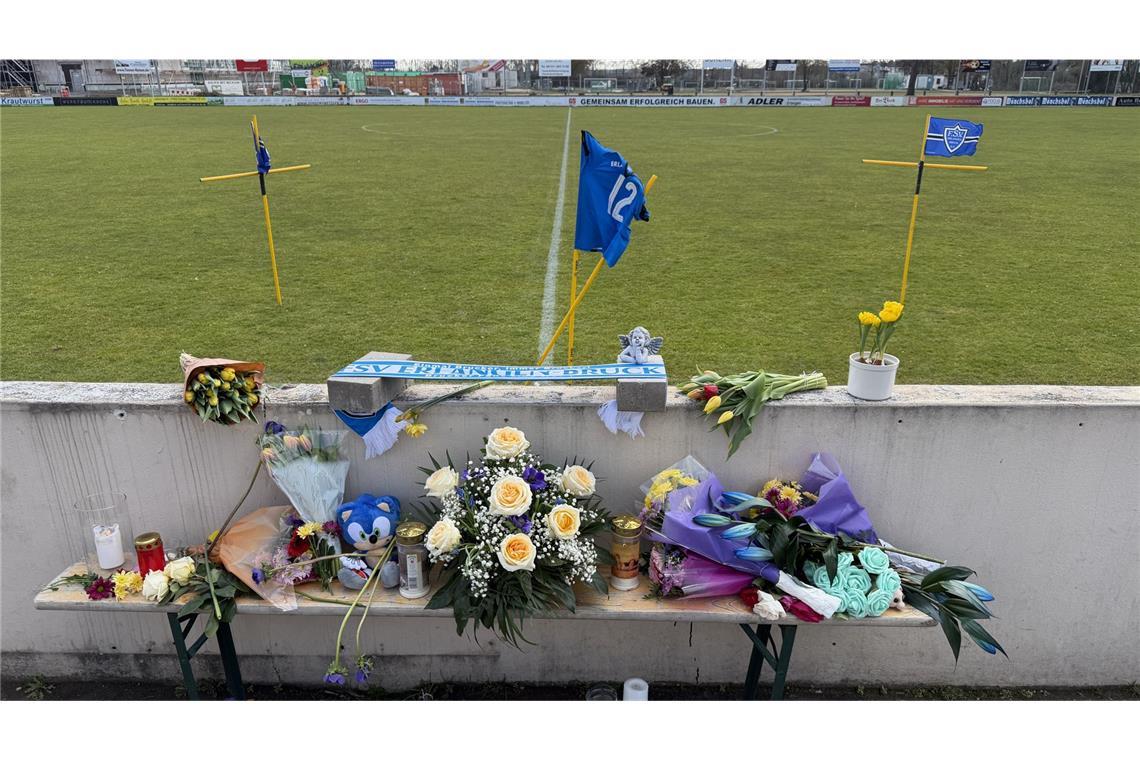 Blumen und Kerzen sind an einem Fußballplatz im Ortsteil Bruck aufgestellt.