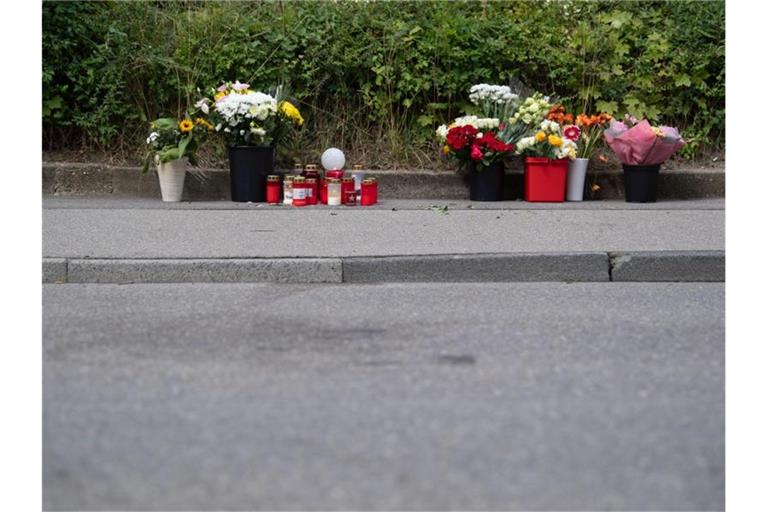 Blumen und Kerzen stehen in unmittelbarer Nähe des Tatorts in Stuttgart. Foto: Marijan Murat/Archivbild