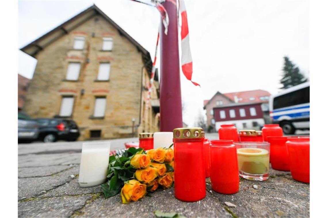 Blumen und Kerzen stehen vor dem Tatort in Rot am See. Foto: Tom Weller/dpa/Archivbild