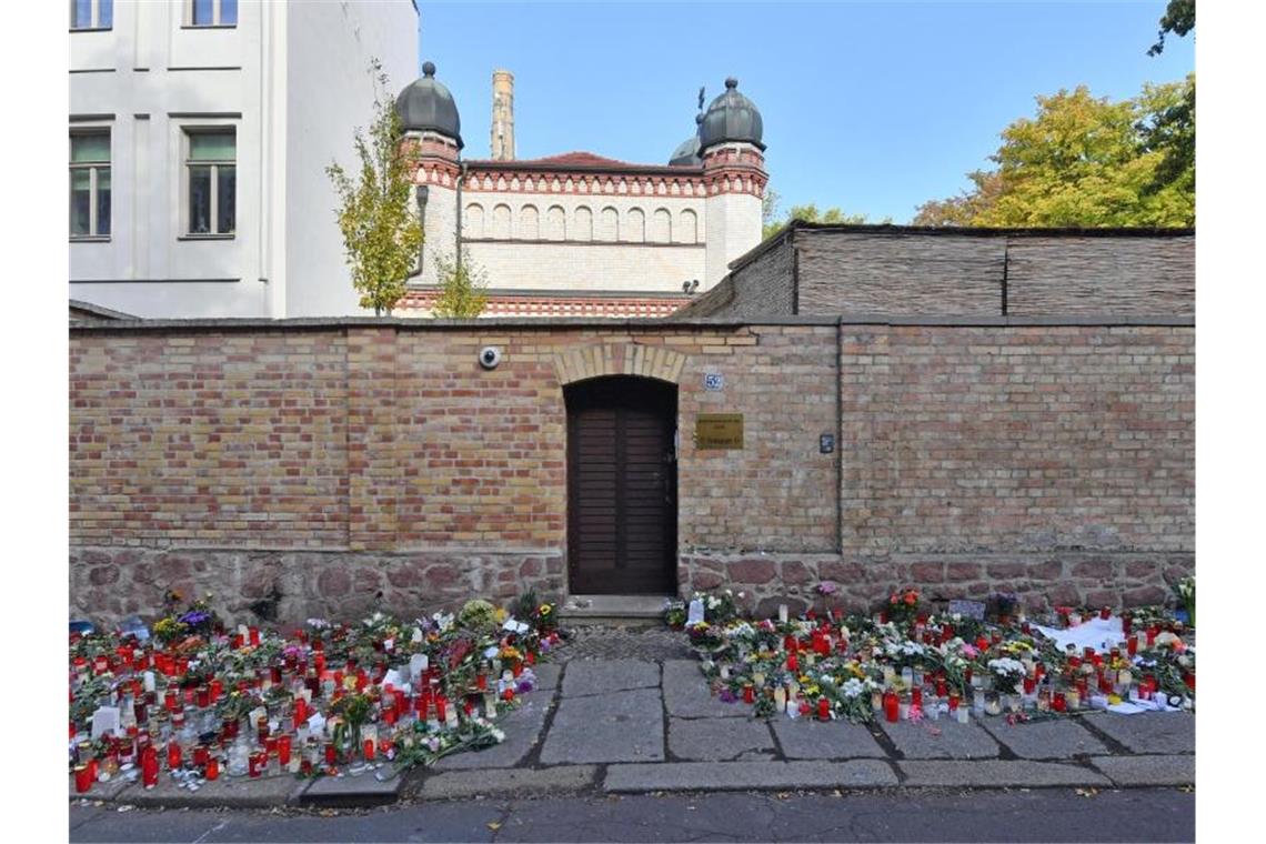 Blumen und Kerzen vor einer Synagoge in Halle (Saale), vier Tage nach dem rechtsextremistischen Anschlag auf die Gemeinde. Foto: Hendrik Schmidt/dpa-Zentralbild/dpa