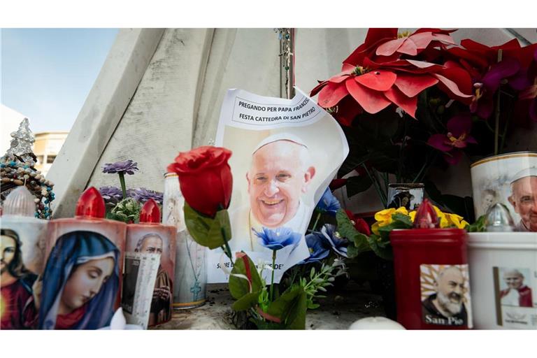 Blumen und Votivkerzen, einige mit dem Abbild von Papst Franziskus, liegen vor dem Gemelli-Krankenhaus in Rom.