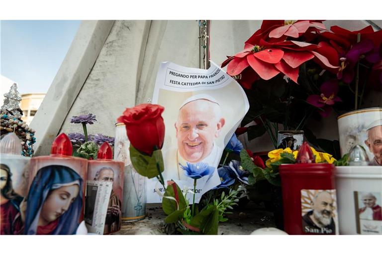 Blumen und Votivkerzen, einige mit dem Abbild von Papst Franziskus, liegen vor dem Gemelli-Krankenhaus in Rom.