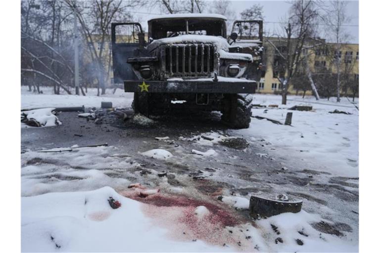 Blut ist im Schnee neben einem zerstörten russischen Militärfahrzeug am Stadtrand von Charkiw zu sehen. Foto: Vadim Ghirda/AP/dpa