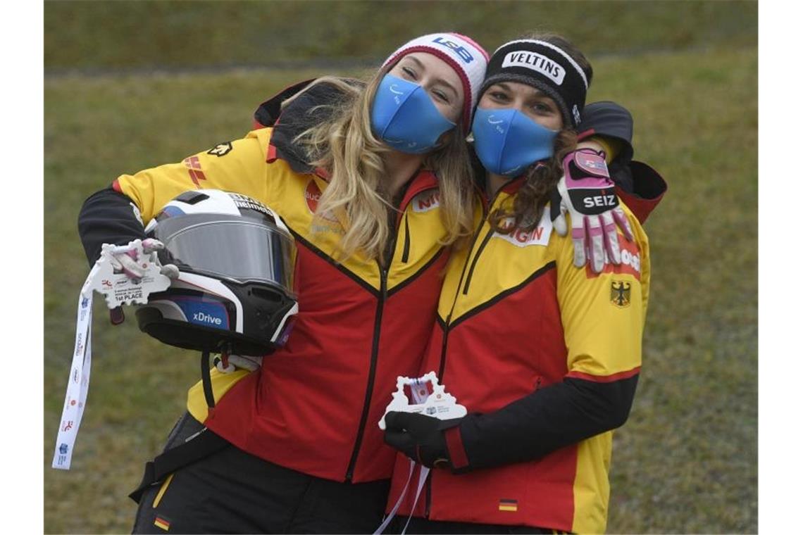 Bob-Pilotin Laura Nolte (l) und Anschieberin Leonie Fiebig feiern ihren Sieg in Sigulda. Foto: Roman Koksarov/AP/dpa