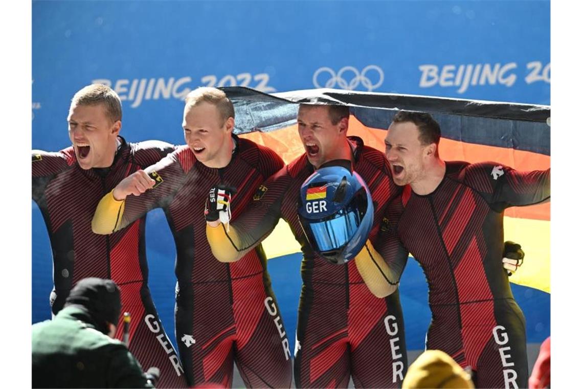 Bobpilot Francesco Friedrich (r) jubelt mit seinem Team über die Goldmedaille. Foto: Robert Michael/dpa-Zentralbild/dpa