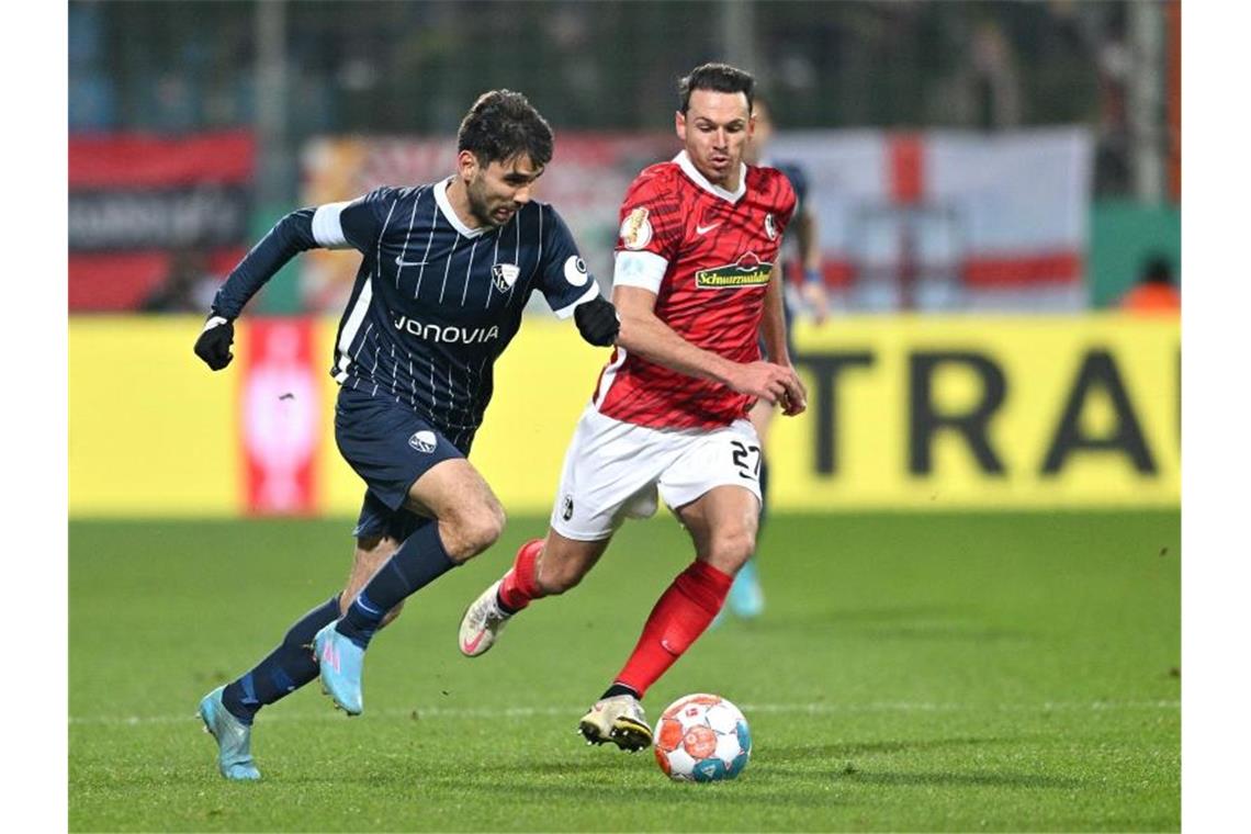 „Vielleicht hilft der Punkt“: Freiburg peilt Europacup an Bochums Gerrit Holtmann (l) und Freiburgs Nicolas Höfler kämpfen um den Ball. Foto: David Inderlied/dpa/Archivbild
