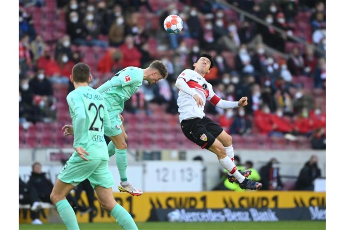 Bundesliga-Samstag: Ein Abstiegskandidat siegt, zwei patzen Bochums Patrick Osterhagey (m) kämpft mit Stuttgarts Wataru Endo (r) um den Ball. Foto: Marijan Murat/dpa