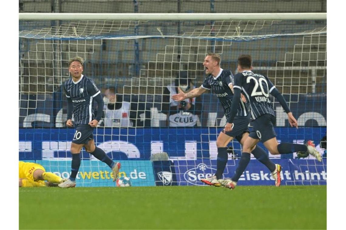 Bochums Takuma Asano (l-r), Sebastian Polter und Elvis Rexhbecaj jubeln nach dem Tor zum 2:2 gegen den 1. FC Köln. Foto: David Inderlied/dpa