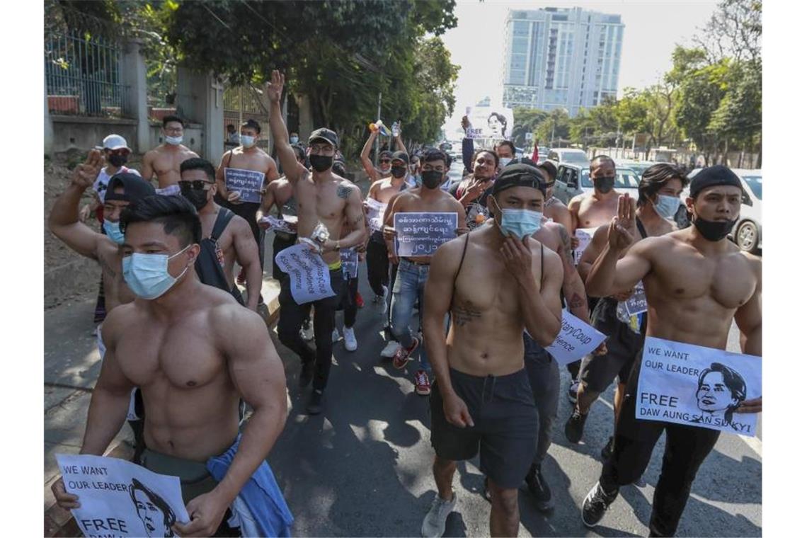 Bodybuilder gegen Putschisten: Demonstranten in Yangon halten Bilder der inhaftierten Regierungschefin Aung San Suu Kyi. Foto: Uncredited/AP/dpa