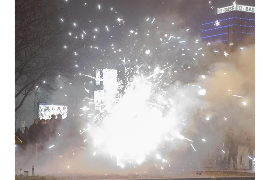 Böller und Raketen steigen auf der Straße an der Oberbaumbrücke in Berlin in die Luft. Foto: Paul Zinken/dpa