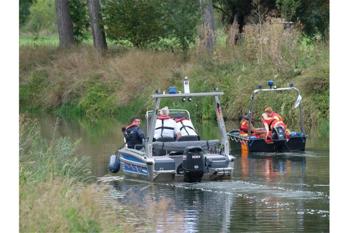 Boote der Wasserschutzpolizei und der Deutschen Lebensrettungsgesellschaft (DLRG) fahren auf der Unstrut. Foto: Sebastian Willnow/dpa-Zentralbild/dpa