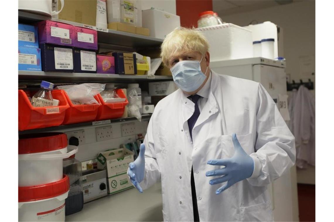 Boris Johnson, Premierminister von Großbritannien, gestikuliert mit seinen Händen und trägt Schutzkleidung und Maske. Johnson hatte sich im April selbst mit Covid-19 infiziert. Foto: Kirsty Wigglesworth/AP POOL/dpa