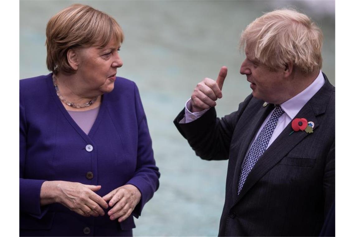 Johnson würdigt Merkel: „Titanin der Diplomatie“ Boris Johnson (r) hat Angela Merkel in einem Gastbeitrag für „Bild“ gewürdigt. Foto: Oliver Weiken/dpa