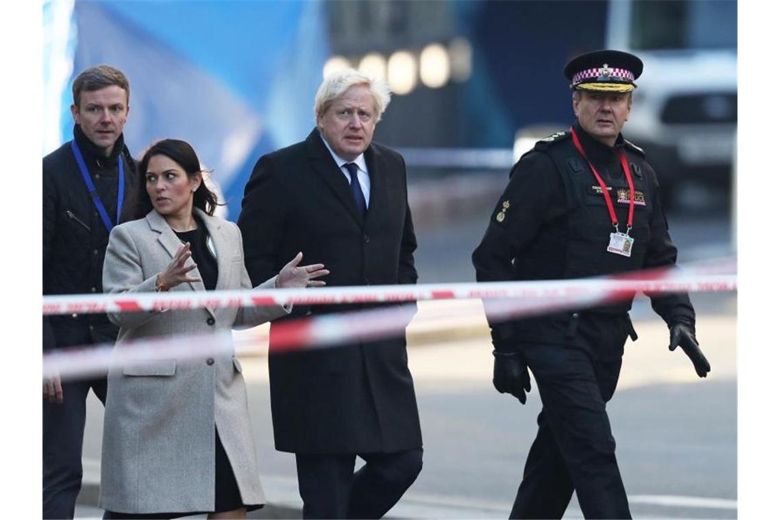 Boris Johnson zusammen mit Innenministerin Priti Patel und Polizisten am Ort der Bluttat auf der London Bridge. Foto: Steve Parsons/PA Wire/dpa
