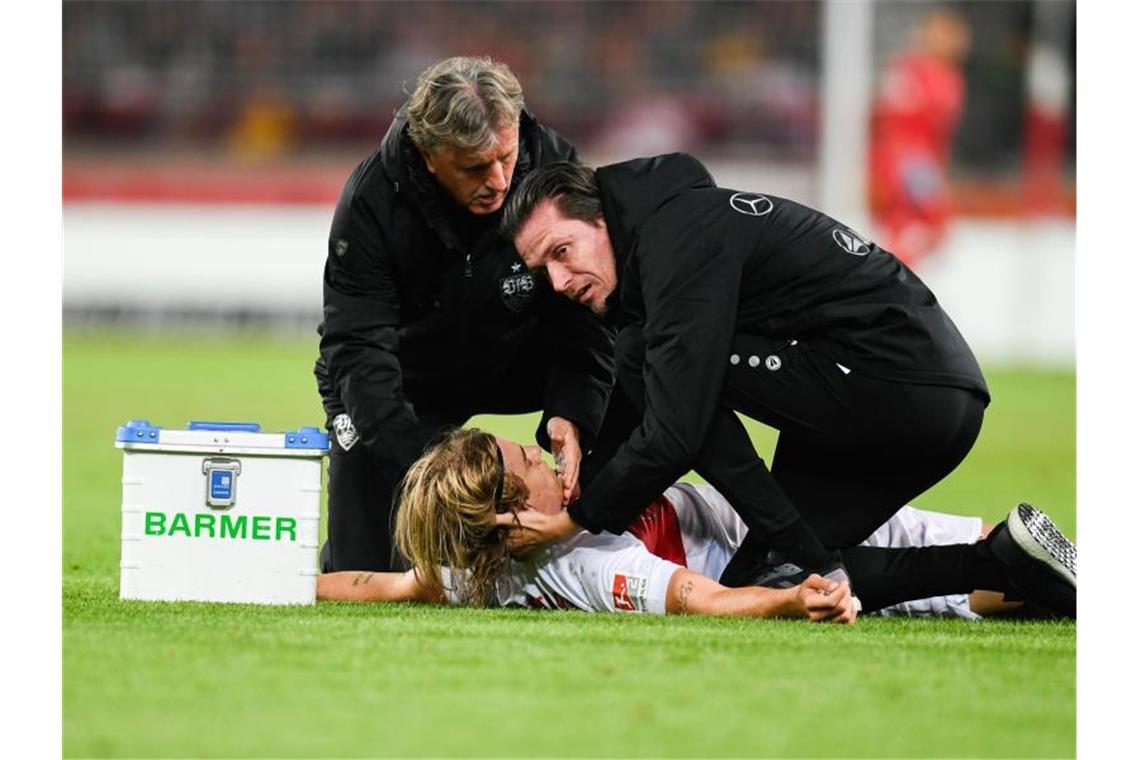 Borna Sosa vom VfB Stuttgart wird von den Mannschaftsärzten behandelt. Foto: Tom Weller/dpa