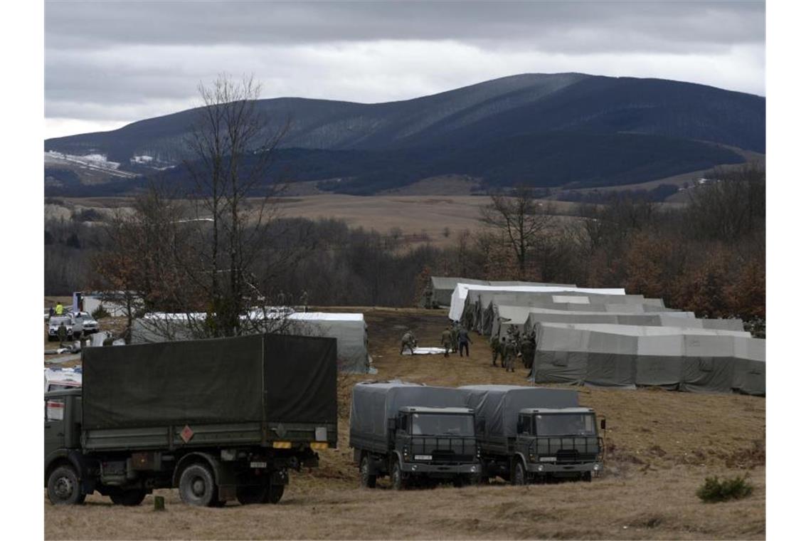 Bosnische Soldaten stehen vor provisorischen Zelten im Camp Lipa außerhalb von Bihac. Nach der gescheiterten Verlegung von Hunderten Flüchtlingen in feste Unterkünfte im Landesinneren hat die bosnische Armee damit begonnen, im Elendslager Lipa im Nordwesten des Landes Zelte zu errichten. Foto: Kemal Softic/AP/dpa