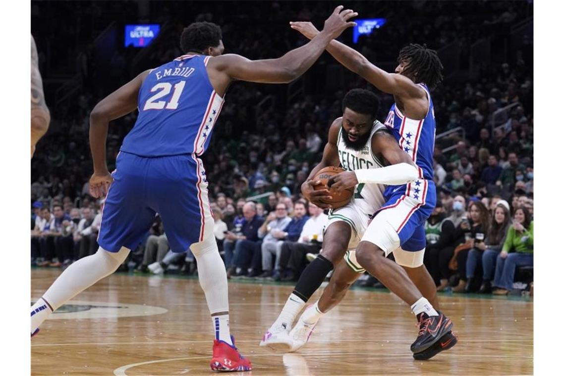 Boston Celtics-Guard Jaylen Brown (M) gegen Philadelphia 76ers-Guard Tyrese Maxey (r) und Center Joel Embiid. Foto: Charles Krupa/AP/dpa