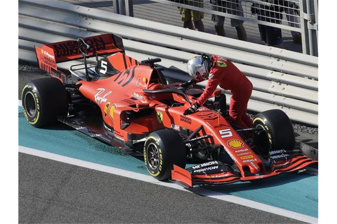Braucht dringend ein neues Dienstfahrzeug: Sebastian Vettel stützt sich auf seinen liegengebliebenen Rennwagen. Foto: Luca Bruno/AP/dpa