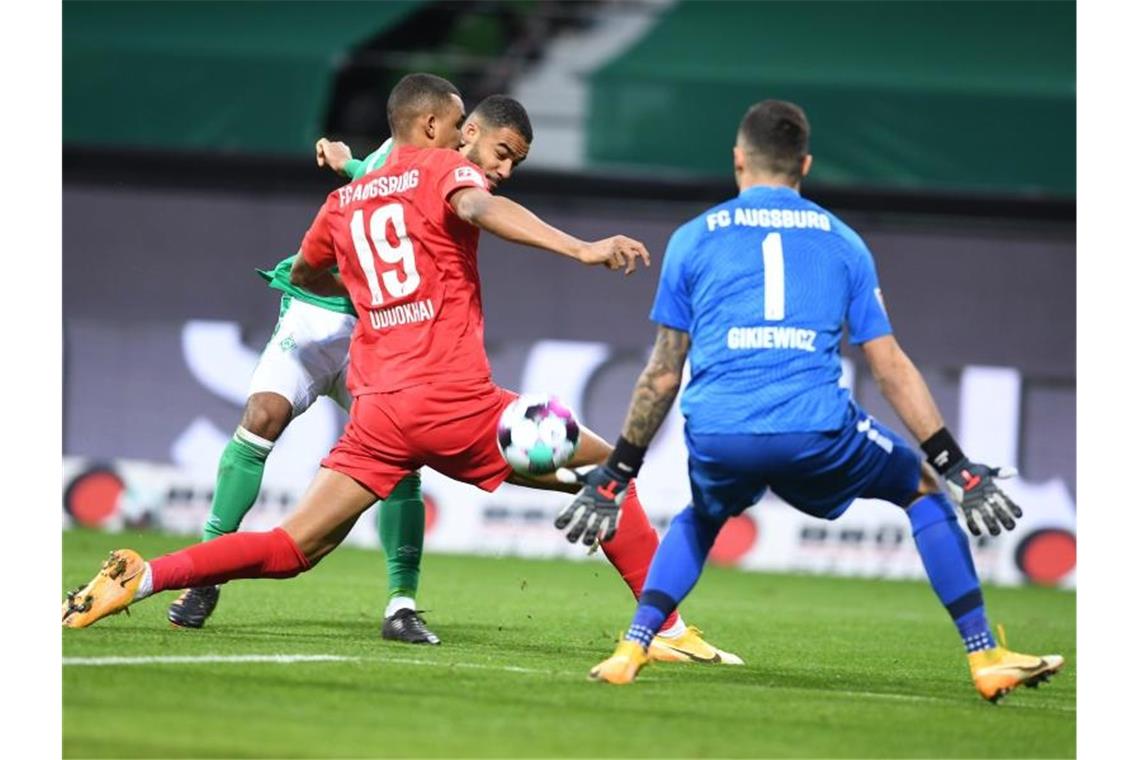 Leipzig verpasst Tabellenspitze - BVB strauchelt gegen Mainz Bremens Jean-Manuel Mbom setzt zum Torschuss an - Augsburgs Torwart Rafal Gikiewicz und Chris Uduokhai versuchen den Ball zu blocken. Foto: Carmen Jaspersen/dpa