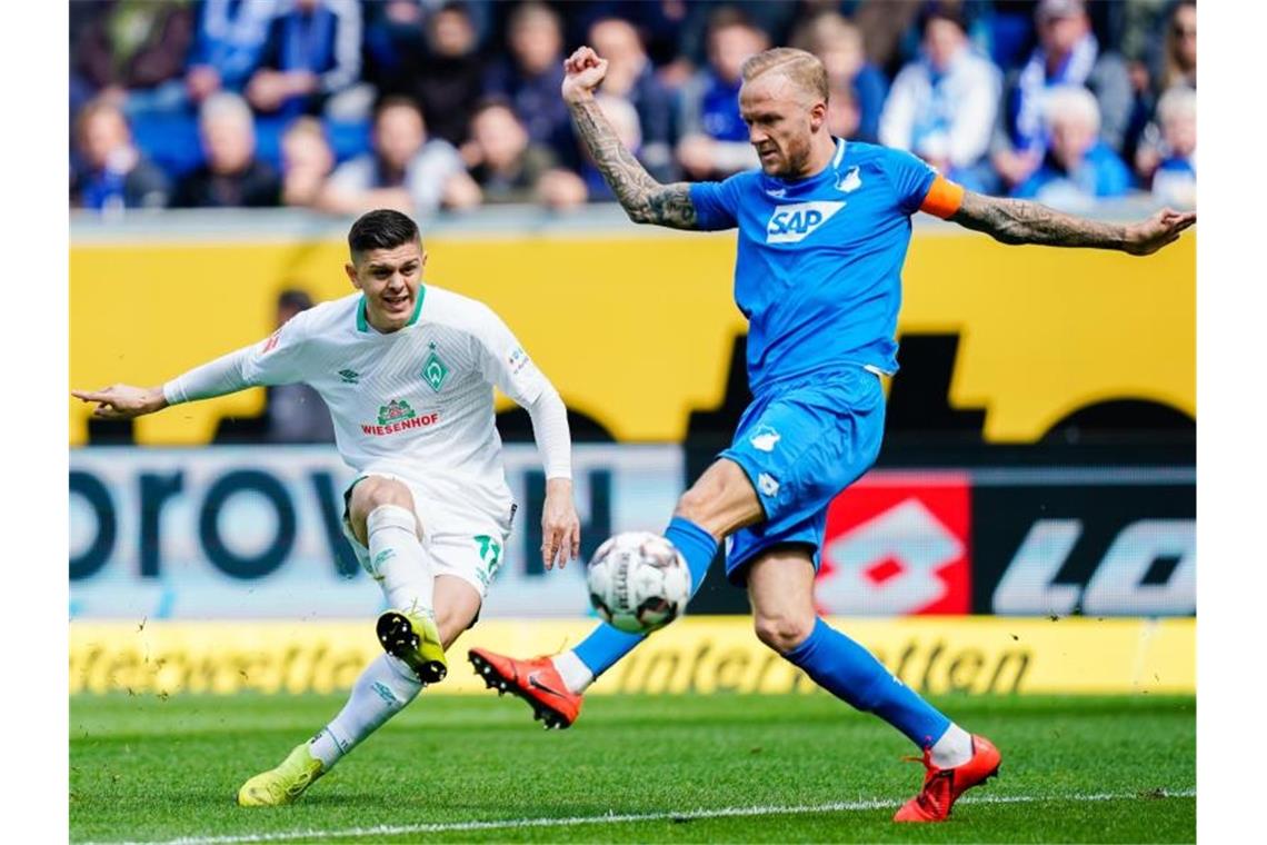 Bremens Milot Rashica (l) und Hoffenheims Kevin Vogt kämpfen um den Ball. Foto: Uwe Anspach/dpa/Archivbild