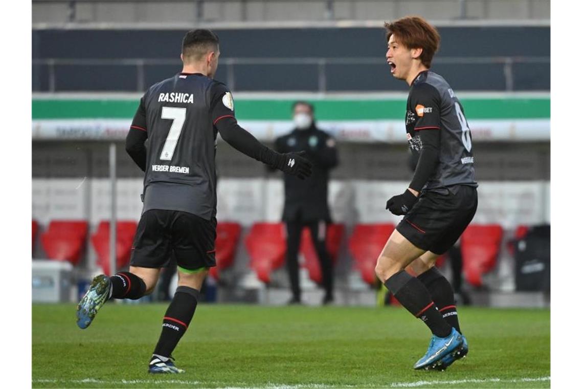 Werder bucht Halbfinal-Ticket gegen wackere Regensburger Bremens Torschütze Yuya Osako feiert mit Milot Rashica (l) das Tor zum 1:0 gegen Jahn Regensburg. Foto: Armin Weigel/dpa
