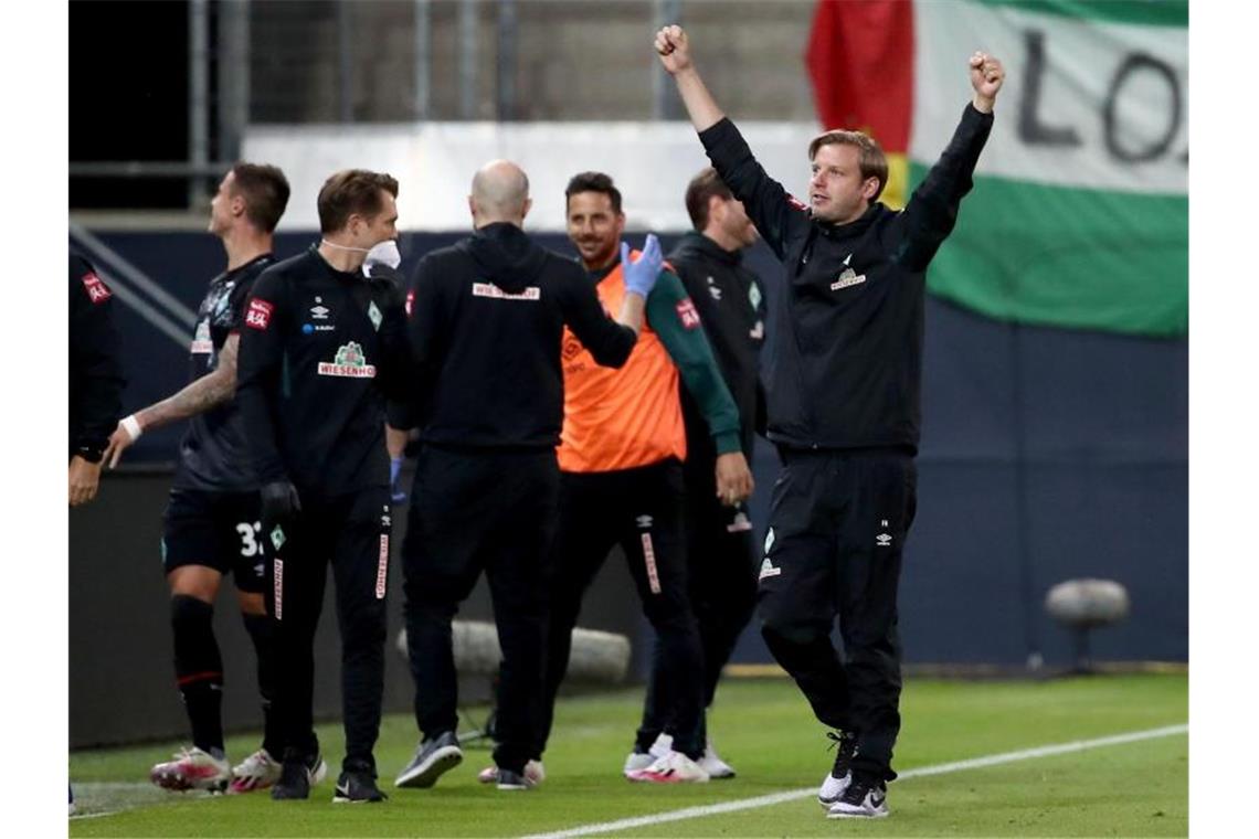 Bremens Trainer Florian Kohfeldt (r) jubelt über den zweiten Treffer gegen den FC Heidenheim. Foto: Tom Weller/dpa