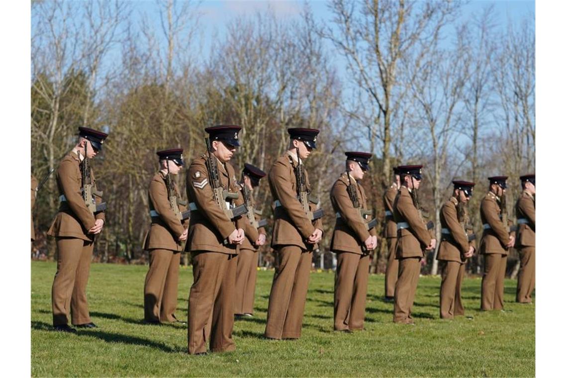 Britische Soldaten bei einer Schweigeminute für Kapitän Sir Thomas Moore. Foto: Joe Giddens/PA Wire/dpa