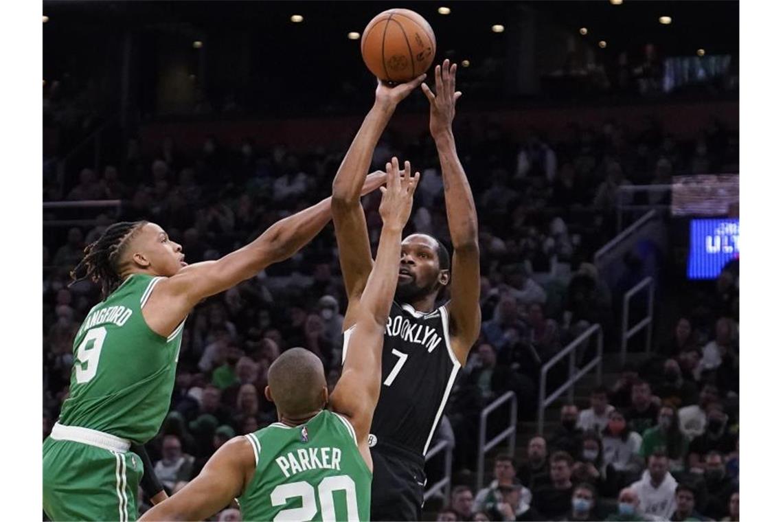 Brooklyn Nets-Forward Kevin Durant (r) wirft, während er von Boston Celtics-Guard Romeo Langford (l) und Forward Jabari Parker verteidigt wird. Foto: Charles Krupa/AP/dpa