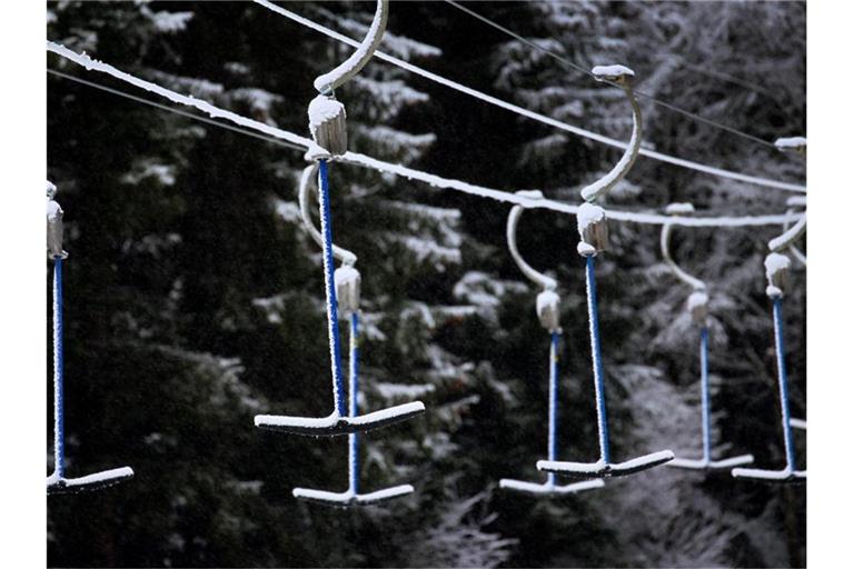 Bügel eines Schleppliftes hängen in schneebedeckter Landschaft. Wegen der Maßnahmen um das Coronavirus müssen Skilifte geschlossen bleiben. Foto: Karl-Josef Hildenbrand/dpa