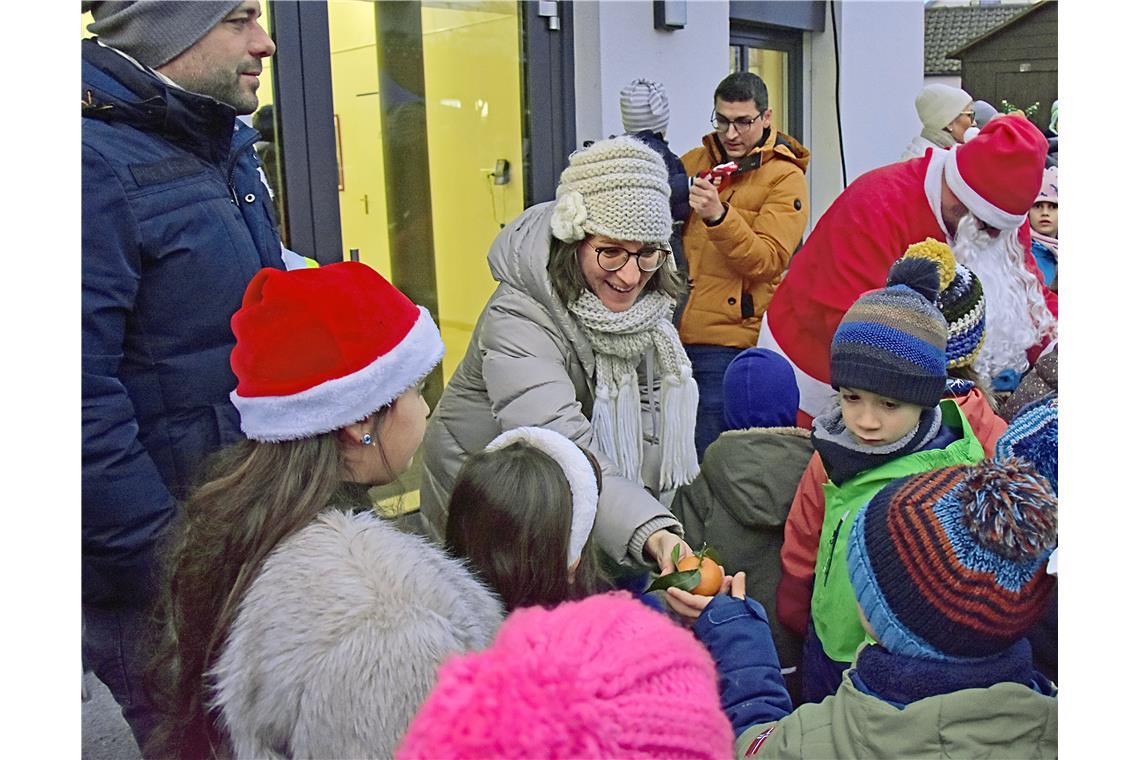 Bürgermeisterin Patrizia Rall verteilt frische Mandarinen an die Kinder. Weihnac...