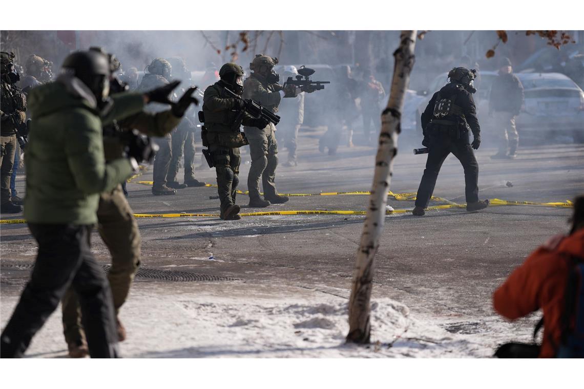 Bundesbeamte der Einwanderungsbehörde setzen nach einem Schussvorfall in Minneapolis Pfefferspray gegen Beobachter ein.