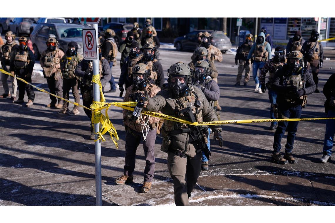 Bundesbeamte der Einwanderungsbehörde setzen nach einem Schussvorfall Pfefferspray gegen Beobachter ein.