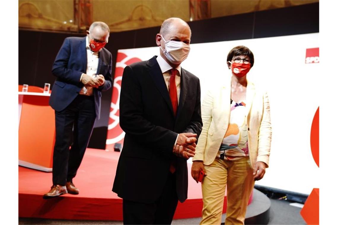 Bundesfinanzminister Olaf Scholz (M) nach seiner Vorstellung als Kanzlerkandidat der SPD durch die Parteichefs Norbert Walter-Borjans (l) und Saskia Esken. Foto: Kay Nietfeld/dpa