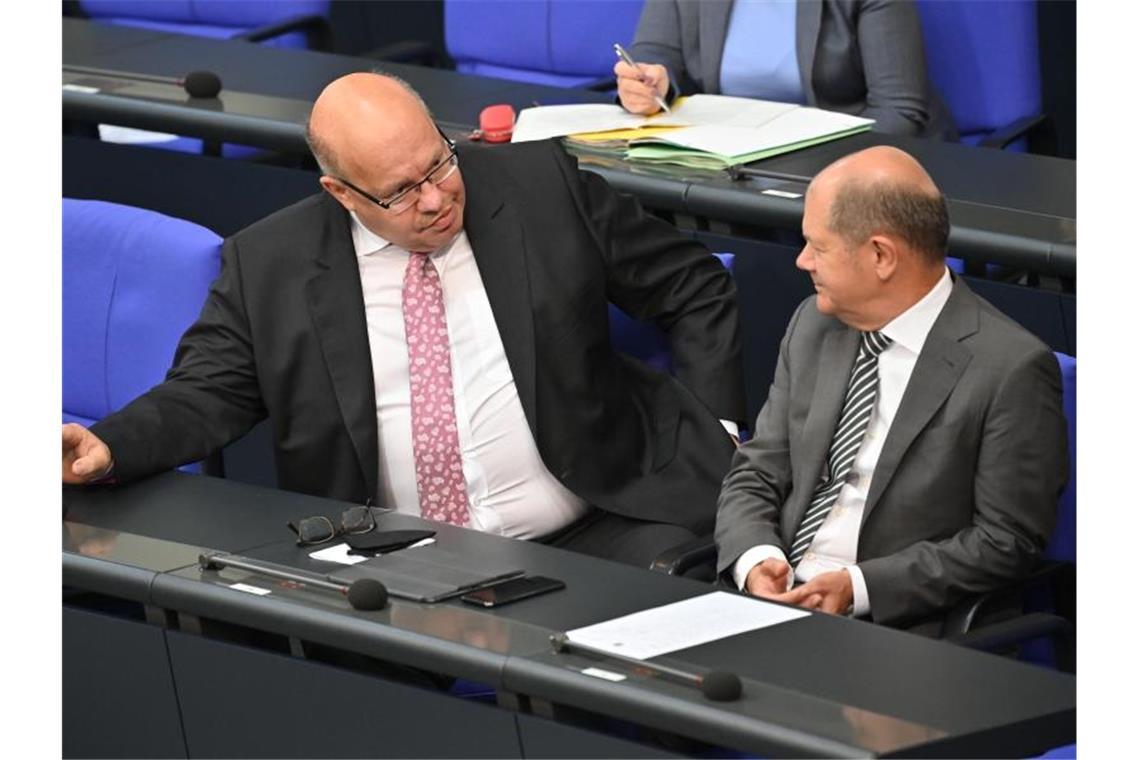 Corona-Wirtschaftshilfen sollen verlängert werden Bundesfinanzminister Olaf Scholz (SPD, r) spricht mit Bundeswirtschaftsminister Peter Altmaier (CDU) bei einer Sondersitzung des Deutschen Bundestages. Foto: Bernd Von Jutrczenka/dpa