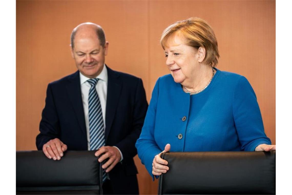Bundesfinanzminister Scholz und Bundeskanzlerin Merkel vor Beginn einer der wöchentlichen Sitzungen des Bundeskabinetts. Foto: Michael Kappeler/dpa