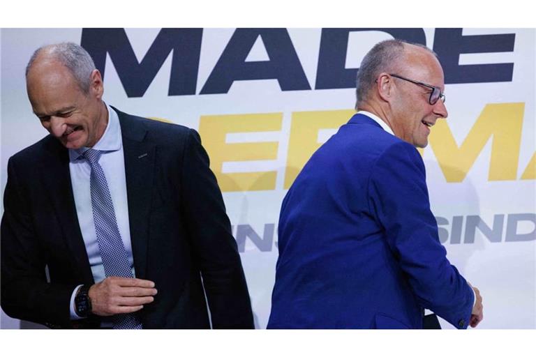 Bundeskanzler Friedrich Merz (CDU, r) geht auf dem Weg zum Rednerpult an Roland Busch, Vorstandsvorsitzender von Siemens, vorbei bei der Veranstaltung der Vorstellung der Jahresbilanz der Initiative Made for Germany. Merz hat Investoren aus der Wirtschaft grundlegende Reformen in Deutschland zugesagt.