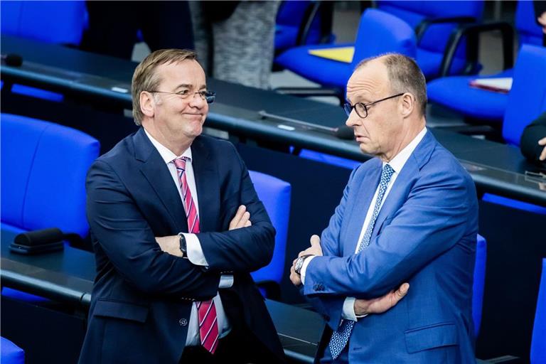 Bundeskanzler Friedrich Merz (CDU, r) und Boris Pistorius (SPD), Bundesminister der Verteidigung, unterhalten sich im Plenum des Deutschen Bundestages.
