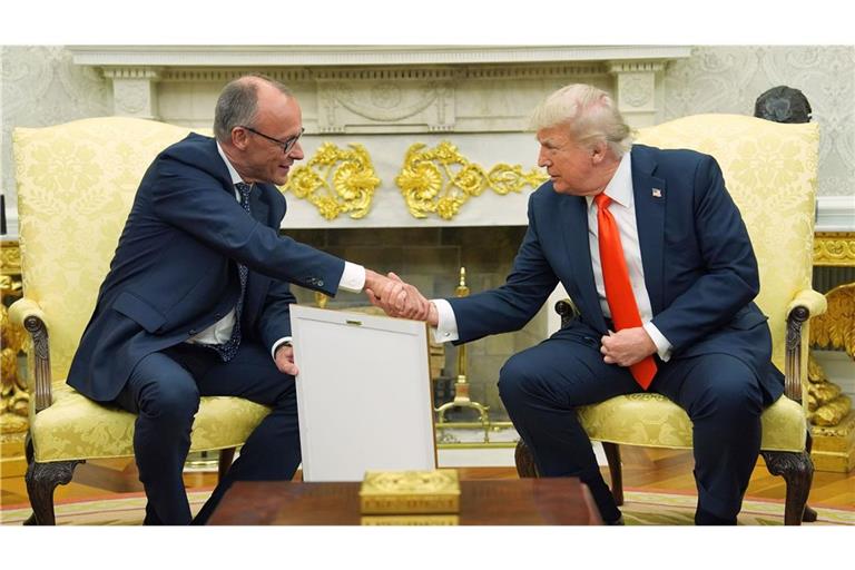 Bundeskanzler Friedrich Merz (l, CDU) überreicht US-Präsident Donald Trump die Geburtsurkunde Trumps Großvaters (Archivbild).