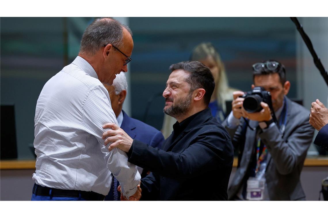 Bundeskanzler Friedrich Merz (l) unterhält sich mit dem ukrainischen Präsidenten Wolodymyr Selenskyj während einer Diskussionsrunde auf dem EU-Gipfel in Brüssel.