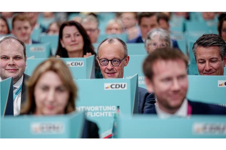 Bundeskanzler Friedrich Merz (M), CDU-Parteivorsitzender, sitzt hinter seiner Wahlkabine.