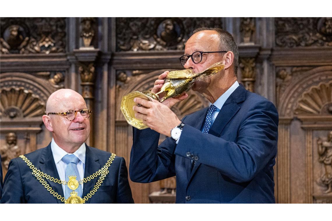 Bundeskanzler Friedrich Merz trinkt bei seinem Antrittsbesuch in Nordrhein-Westfalen aus dem goldenen Hahn der Stadt Münster.