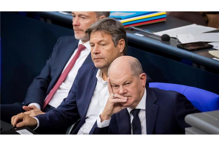 Bundeskanzler Olaf Scholz (SPD, r-l), Wirtschaftsminister Robert Habeck (Bündnis 90/Die Grünen) und Finanzminister Christian Lindner (FDP) verfolgen im Deutschen Bundestag die Debatte.