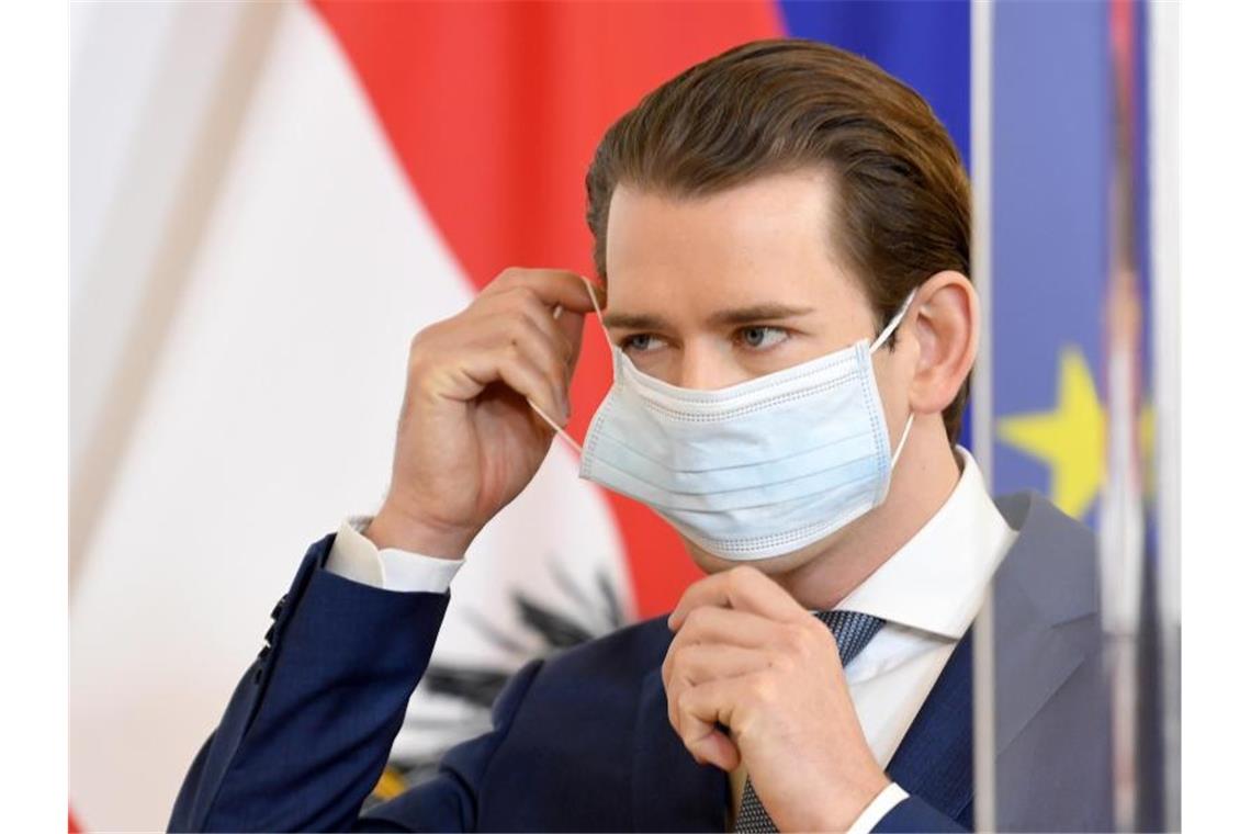 Corona global: Wie ein Virus die Welt verändert Bundeskanzler Sebastian Kurz rückt seinen Mundschutz während einer Pressekonferenz zurecht. Foto: Roland Schlager/APA/dpa