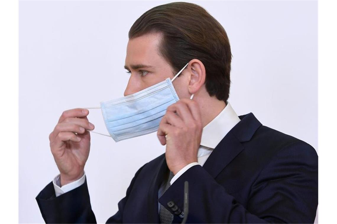 Bundeskanzler Sebastian Kurz setzt bei einer Pressekonferenz zum Thema „Coronavirus: Aktuelles“ im Bundeskanzleramt seine Schutzmaske ab. Foto: Helmut Fohringer/APA/dpa