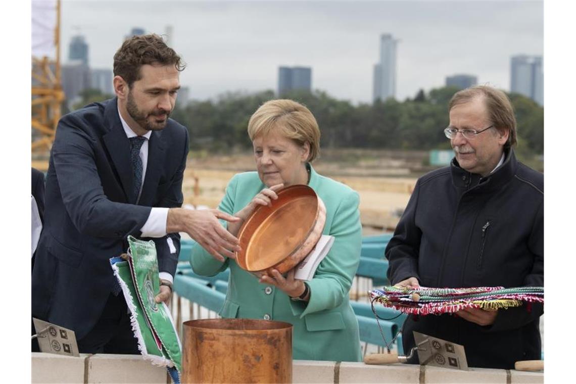 Bundeskanzlerin Agela Merkel (M) packt bei der Grundsteinlegung zur DFB-Akademie mit an. Foto: Boris Roessler