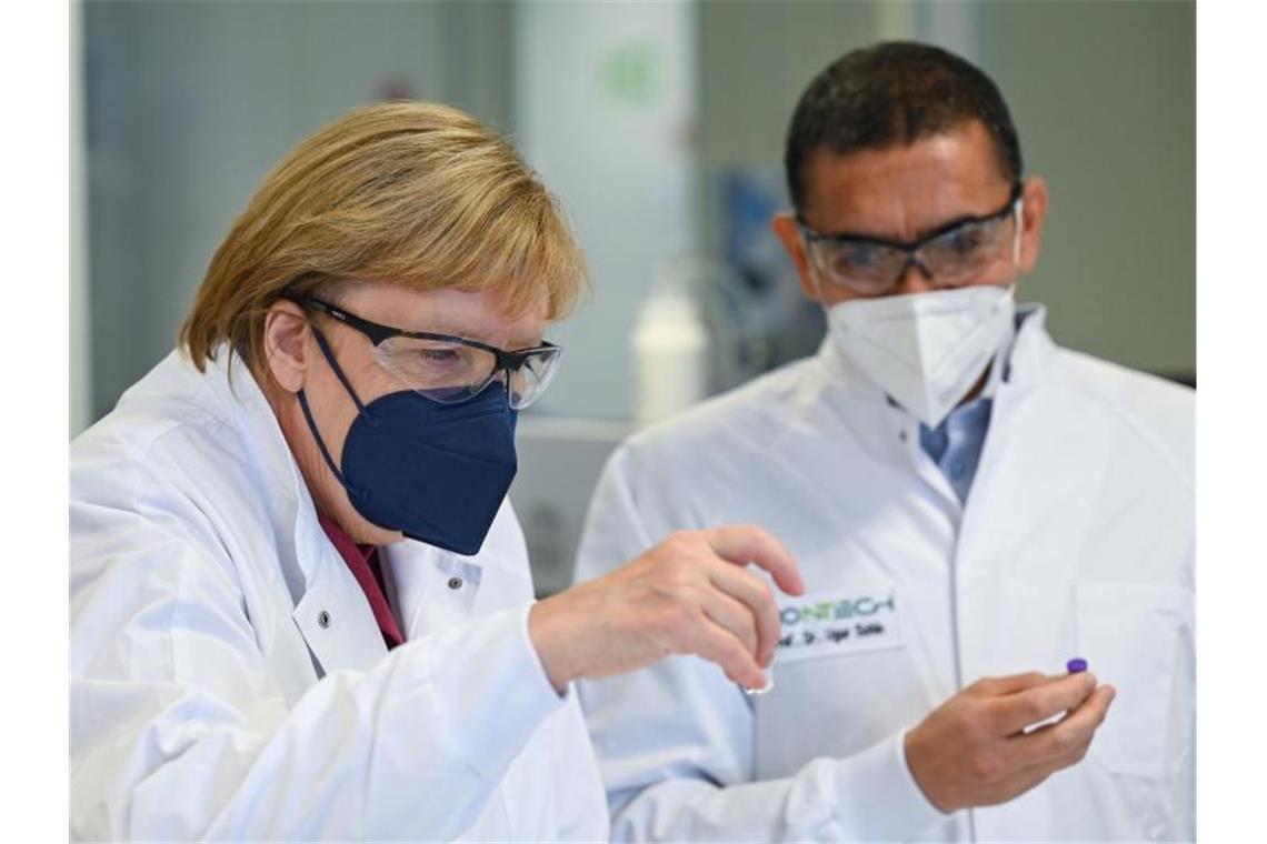 Bundeskanzlerin Angela Merkel besucht das Werk des Impfstoffherstellers Biontech in Marburg. Vorstandschef Ugur Sahin führt sie durch die Räume. Foto: Arne Dedert/dpa/POOL/dpa