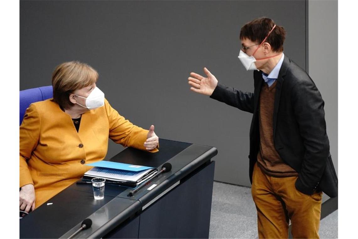 Linke und FDP fordern Vertrauensfrage von Merkel Bundeskanzlerin Angela Merkel (CDU) diskutiert mit SPD-Gesundheitsexperte Karl Lauterbach. Foto: Kay Nietfeld/dpa