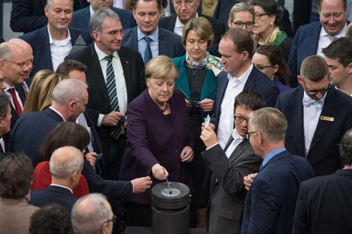 Bundeskanzlerin Angela Merkel (CDU) und weitere Abgeordnete stimmen bei der 128. Sitzung des Deutschen Bundestages namentlich ab. Debattiert wird der Tagesordnungspunkt "Klimaschutz". Foto: Jörg Carstensen/dpa