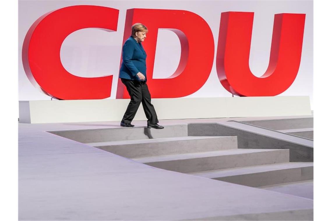 Parteitag in Leipzig: CDU räumt Streitfragen aus Bundeskanzlerin Angela Merkel geht beim Bundesparteitag auf dem Podium die Treppe hinab. Foto: Kay Nietfeld/dpa