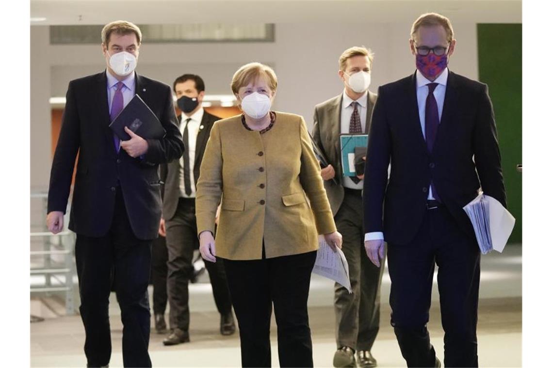 Bundeskanzlerin Angela Merkel, kommt neben Bayens Ministerpräsident Markus Söder und Berlins regierenden Bürgermeister Michael Müller zur Pressekonferenz nach den Beratungen von Bund und Ländern. Foto: Michael Kappeler/dpa-pool/dpa